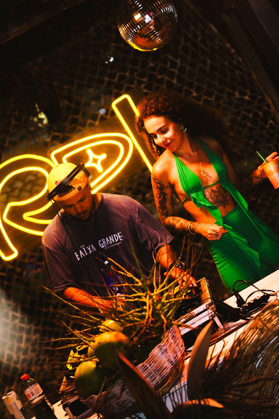 DJs tocando sob o letreiro neon RDL no bar da praia